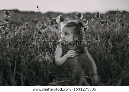 Emotional girl in poppy field, black and white photo