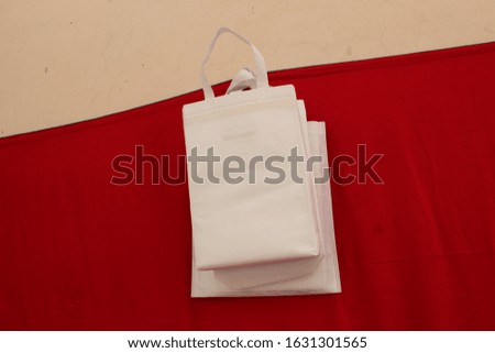 white Non Woven Polypropylene Fabric Shopping Bags with red background