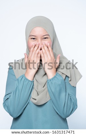 Beautiful muslim laughing and giggling while covering mouth.