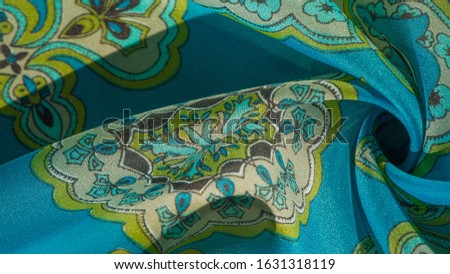 texture, background, multicolored silk fabric with a pattern of patterns on a turquoise background,