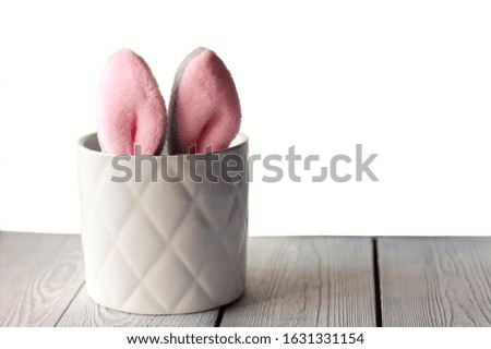 Easter bunny ears showing in flower pot. Toy bunny in a pot. Cute easter design, copy space for text