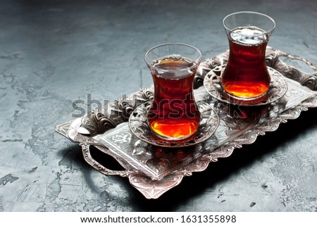 Delicious Turkish  tea in traditional  glass cups armudu  on metal tray