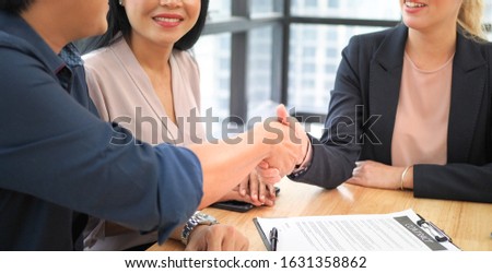 Side view of Shakehand shot between customers and suppliers on signing business contract moment in the office's table. Successful on dealing feeling.