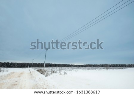 Blue sky with snow field and road. Great background with copyspace. Winter and snow landscape. Stock photo.