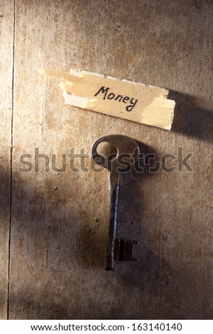 Key to money. Old key and sign " money".