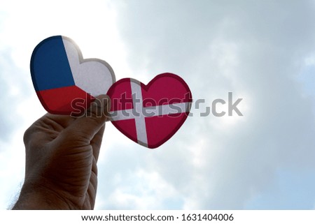 Hand holds a heart Shape Czech Republic and Denmark flag, love between two countries