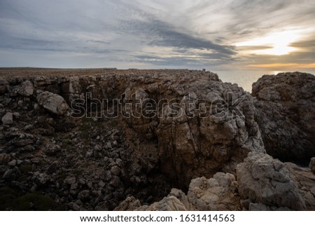 Seascape view of sunset. Beautiful cliffs of Menorca island  north-west coast at Punta Nati lighthouse area. 