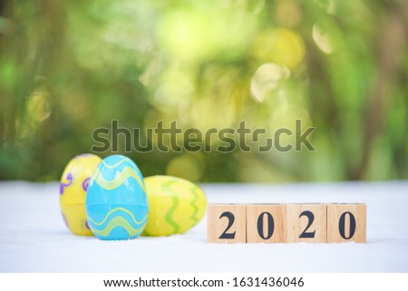Word text blocks 2020 with colorful easter eggs background. Festive decoration.