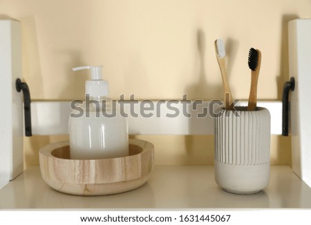 Shelving unit with toiletries near light wall indoors. Bathroom interior element