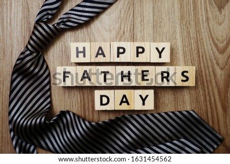 Happy Father's Day alphabet letters with necktie on wooden background