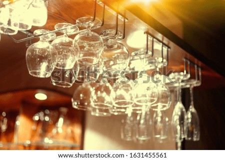 Empty  glasses hanging above the bar in the restaurant. Night life 