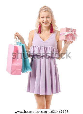 Beautiful young woman with gift and shopping bags on white background. International Women's Day celebration