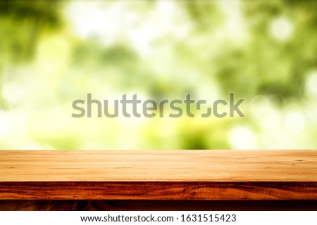 Desk of free space and green blurred spring background. 