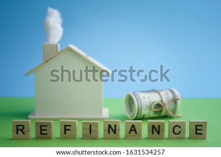 Mortgage and Home refinance conceptual with wooden house on green and blue background
