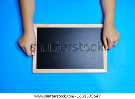 Close-up of a picture using a blank blackboard for a separate presentation or invitation on a blue background.