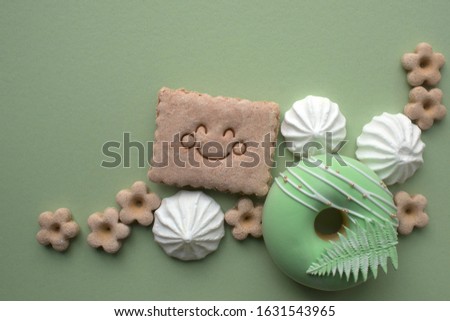 Happy cookies on a green background with meringues. Summer card concept.