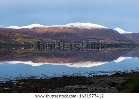 Reflection of snowy mountains in Scottish Loch