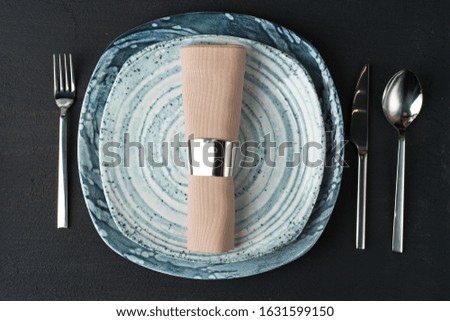 Table setting. Plates with abstract pattern on black table
