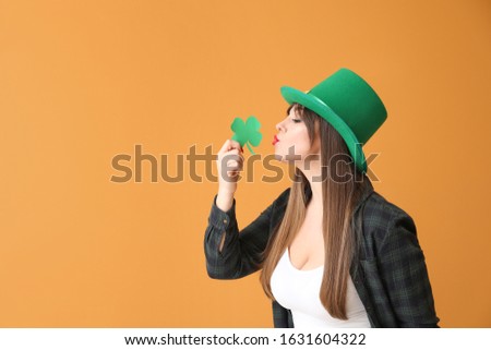 Funny young woman with paper clover on color background. St. Patrick's Day celebration