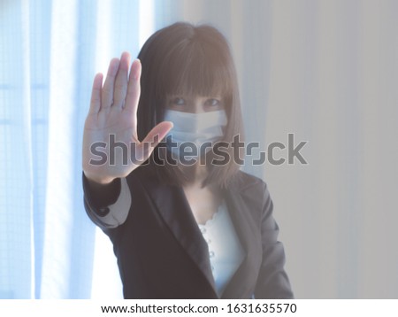 ฺCorona Covic-19 with Blur image of asia woman with Black shirt wearing the respiratory protection mask against air pollution and dust particles exceed the safety limits. she Raise your hand stop it.
