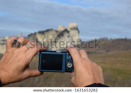 woman's hands photographing a castle