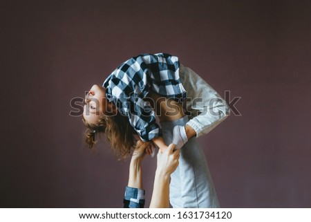 Little cute girl does an acrobat exercise with her mother in studio. Closeup portrait