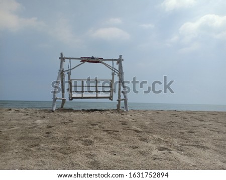 Rocking chair stand alone on the shore.grey sky 