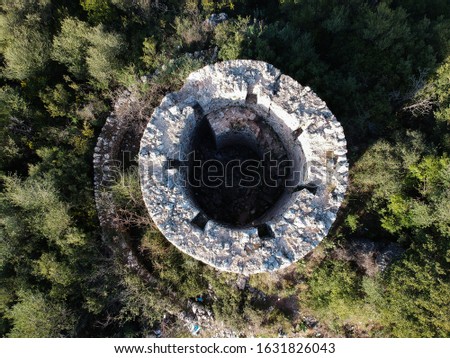 windmill ruins and remains destroyed old windmill is abandoned on a hilltop with panoramic view. circular stone building small industrial plant milled corn,wheat and made flour igoumenitsa greece 