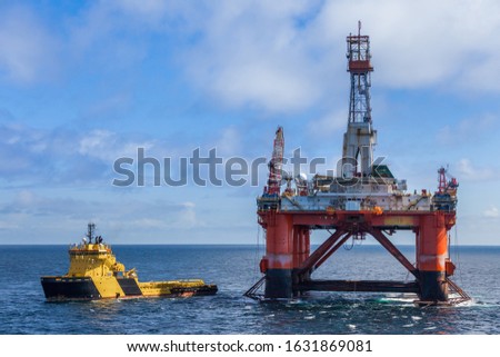NORTH SEA NORWAY - 2015 MAY 25. The semi-submersible drilling rig Transocean Leader with anchor handler vessel Balder Viking alongside. Royalty-Free Stock Photo #1631869081