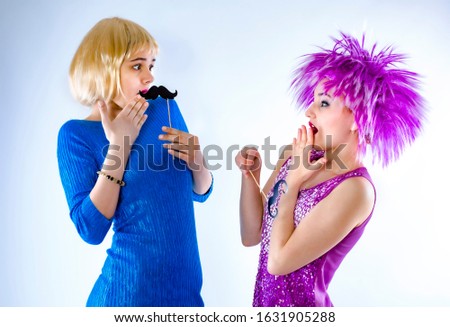 Close-up portrait of two shocked nice attractive lovely charming cute funny girlish girls wearing wigs open mouths isolated on gray rbackground
