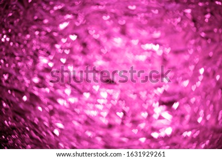 Sparkling spots of figured Bokeh - Valentine's day, pink background with shining hearts.