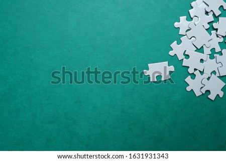 Jigsaw Puzzle pieces on green background stock photo.