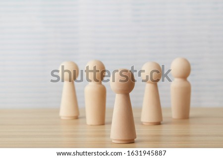 Team leader concept with wooden people figures on desk table