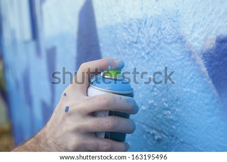 Hand Holding a Spray Paint Can Royalty-Free Stock Photo #163195496