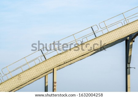 A roller coaster ride with a blue cloudy sky in the background