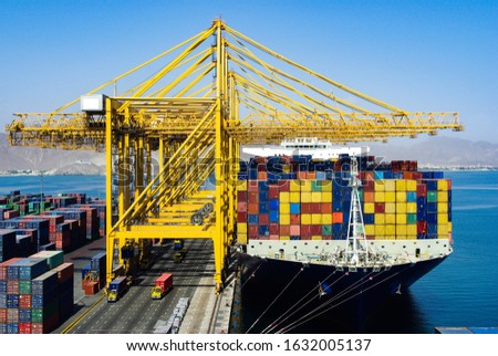 Ultra large container carrier ship in the port Khorfakkan has loading and discharging operations by many gantry cranes. Royalty-Free Stock Photo #1632005137