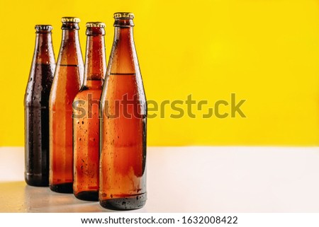 Bottles of beer in different colors. Light and dark beer. Beer background for advertising, chilled drink