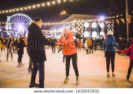 Couple in Love. Romantic Characters for Feast of Saint Valentine. True love. Happy Couple Having Fun at city ice rink in the evening. Happy romantic young couple enjoying together in skating-rink.