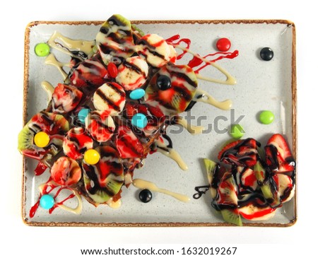 Belgium waffles with chocolate sauce, ice cream and strawberries isolated on white background top view