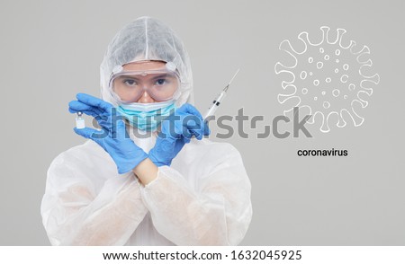 Biological hazard. Epidemic of the Chinese coronavirus. An asian woman in a protective suit and mask holds an injection syringe and vaccine. Vaccine from, flu, coronavirus, ebola, TB.  Royalty-Free Stock Photo #1632045925