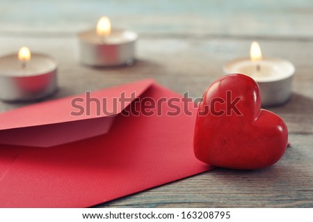 Red envelop with stone heart and candles on wooden background Royalty-Free Stock Photo #163208795