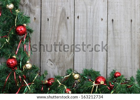 Green garland border with ornaments on wooden fence