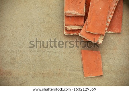 Flat lay of several decorative yellow bricks on the concrete floor. Repair work on the replacement of tiles. Copy space.