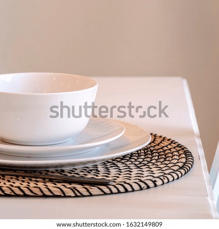 Photo Square Dining table of home with placemat plate saucer bowl utensils and fork