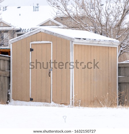 Photo Square frame Wooden shed with snowy roof at the snow covered backyard of home in winter