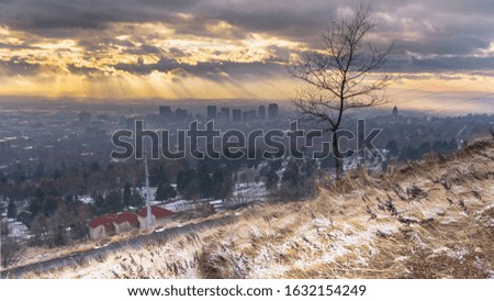Photo Panorama Golden setting sun and dark cloudy sky over downtown Salt Lake City in winter
