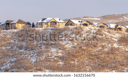Photo Panorama Snow covered hillly terrain with residential neighborhood against cloudy sky