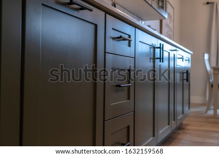 Beautiful cabinetry with black handles and drawers under white countertop Royalty-Free Stock Photo #1632159568