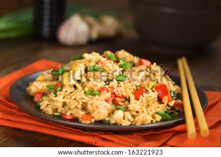 Homemade Chinese fried rice with vegetables, chicken and fried eggs served on a plate with chopsticks (Selective Focus, Focus one third into the dish) Royalty-Free Stock Photo #163221923