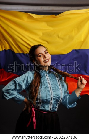 Smiling dark-haired girl on the background of the flag of Colombia